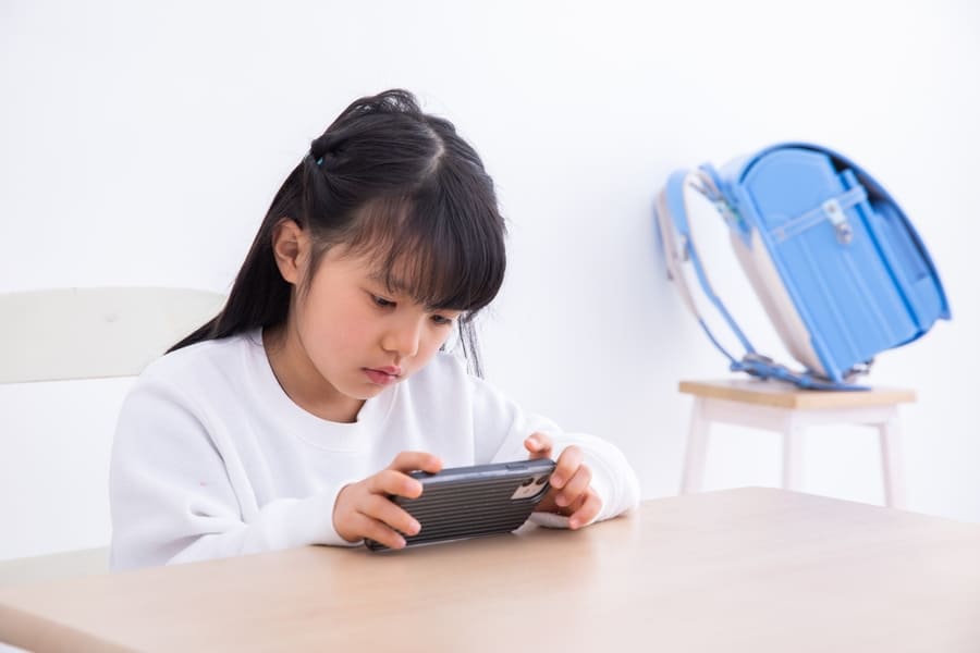 顔より下でスマホをする子ども