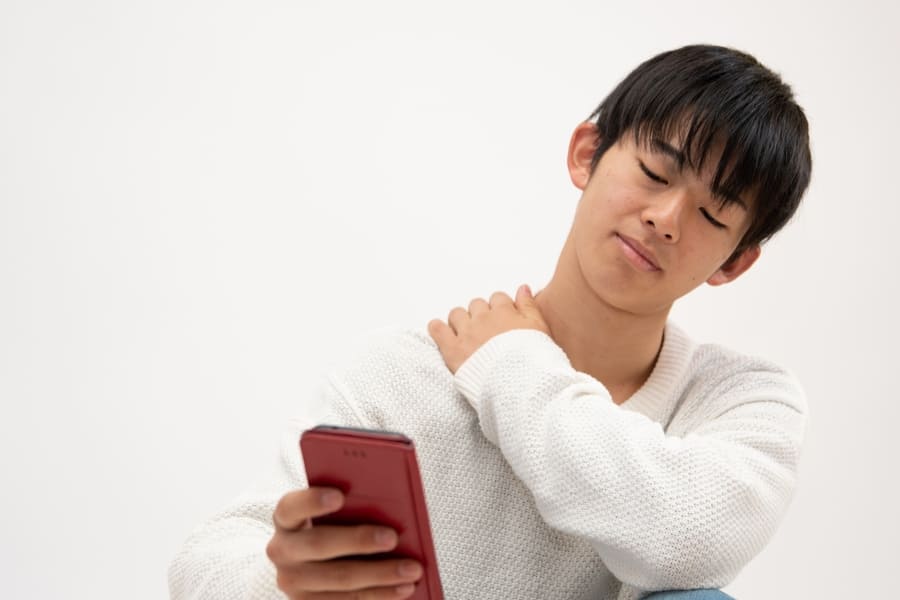 スマホのし過ぎで肩こりを感じている子ども
