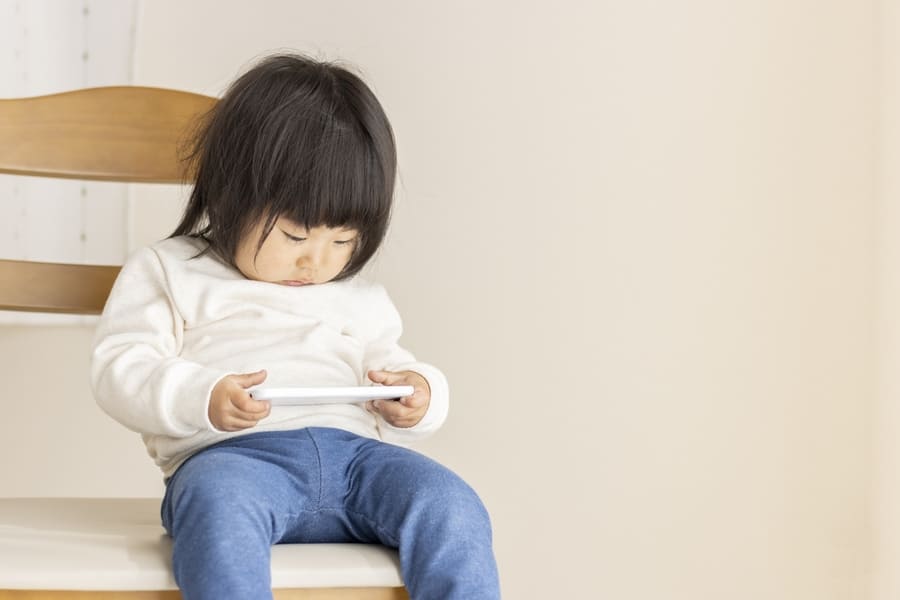 悪い姿勢でスマホを見る子ども
